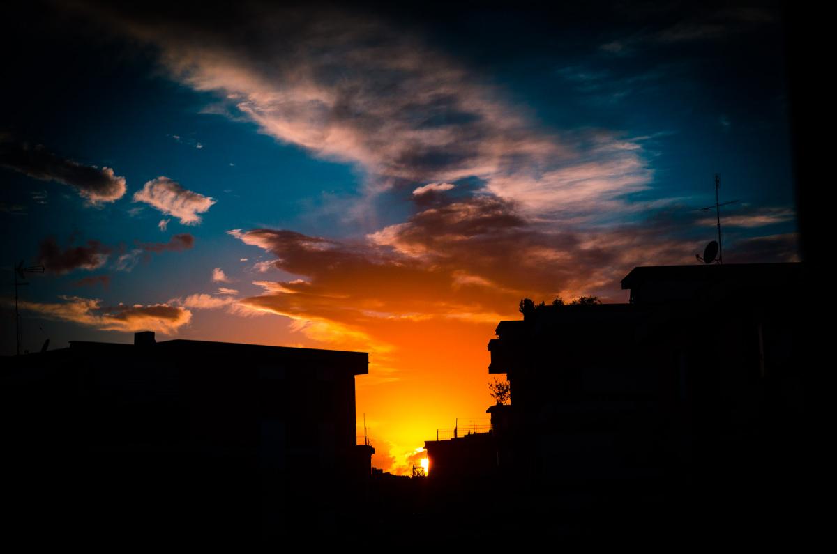Tramonto in città a Latina tra i palazzi skyline e nuvole sole al tramonto sfumature